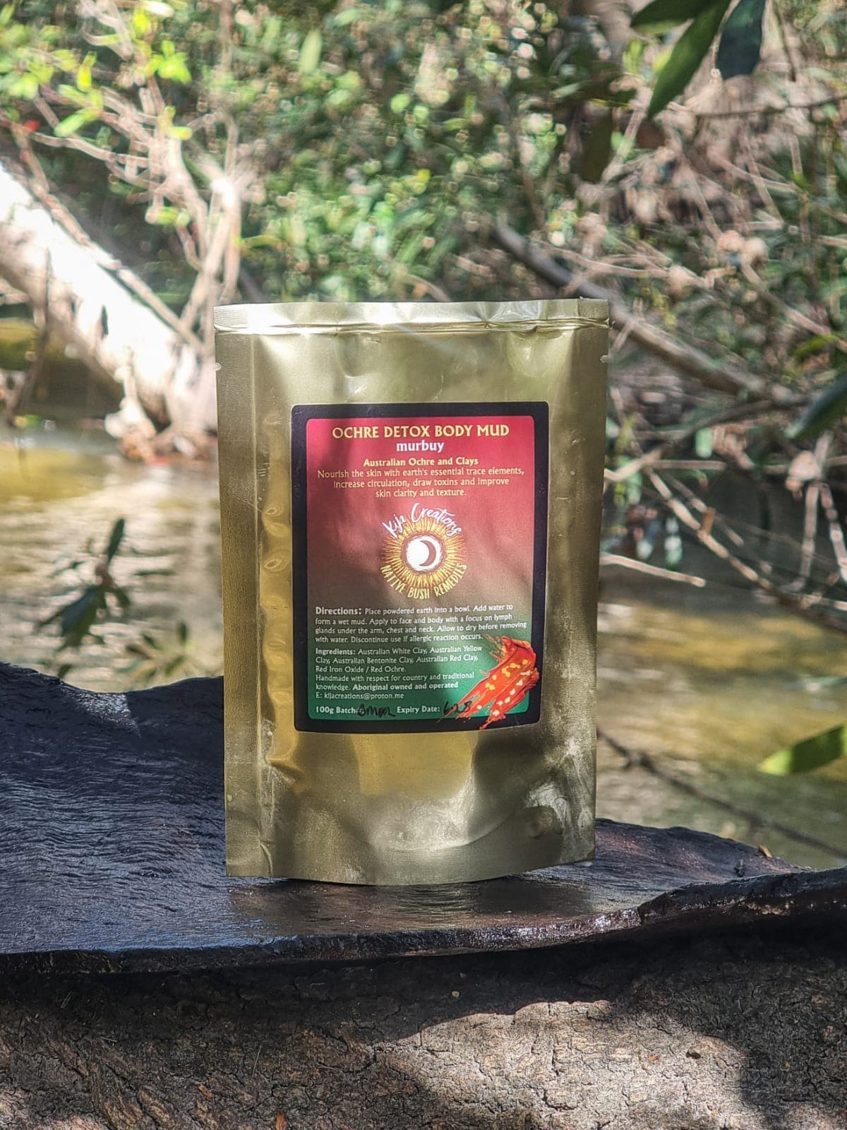 Ochre Detox Body Mud standing beside creek water on Country.