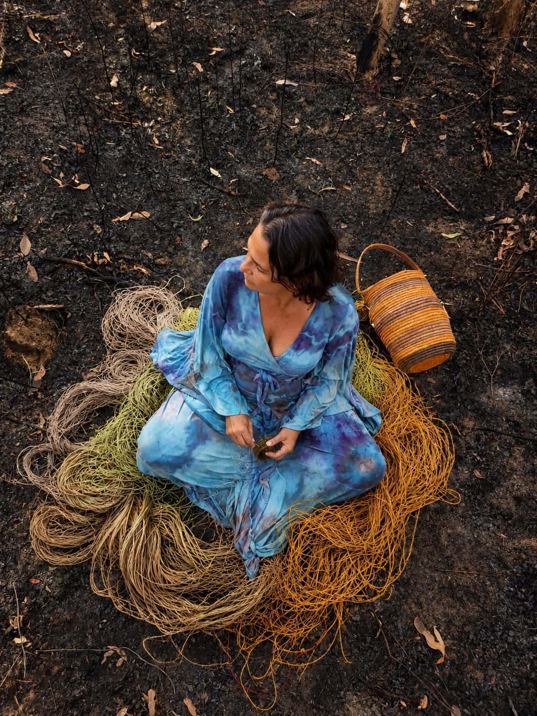 Closer overhead view of Julie weaving with prepared natural fibres.