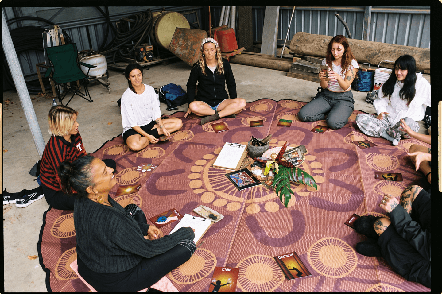 Workshop participants sitting together in a circle for cultural learning and reflection.